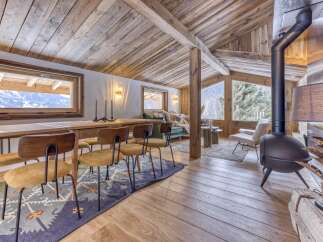 Experience rustic elegance in this stunning chalet, featuring exposed wooden beams and a cozy fireplace.
