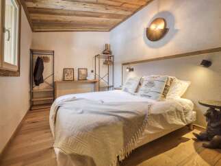 Experience rustic charm in this cozy bedroom, featuring a wooden ceiling and hardwood floors.
