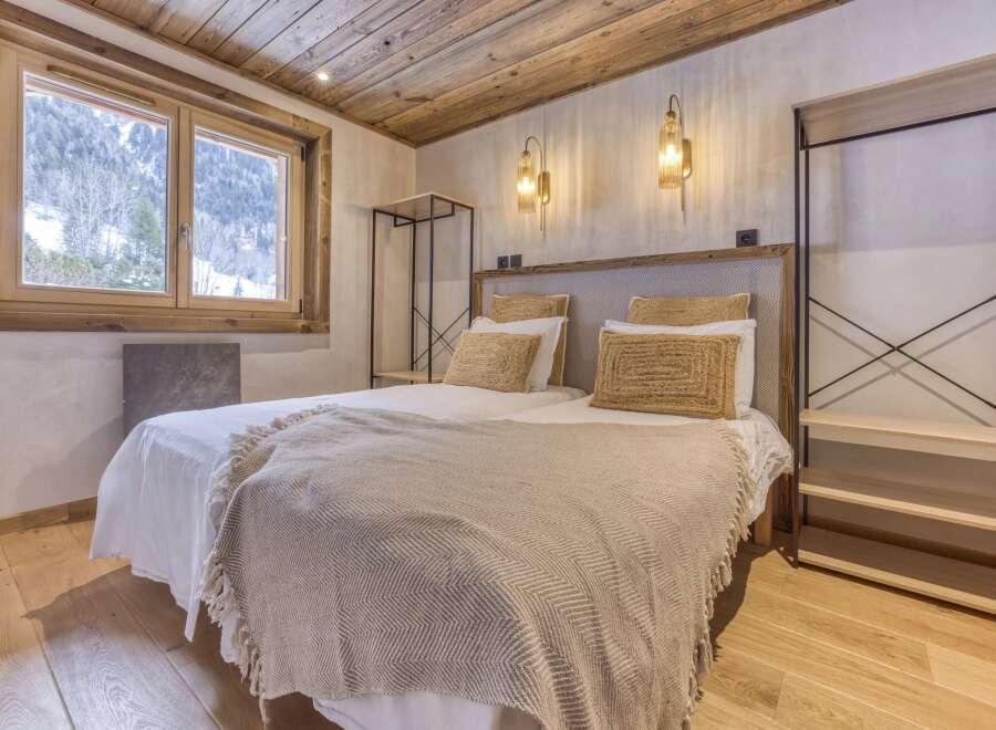 This cozy bedroom features a rustic wooden ceiling and flooring, creating a warm and inviting atmosphere.