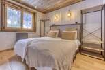 This cozy bedroom features a rustic wooden ceiling and flooring, creating a warm and inviting atmosphere.