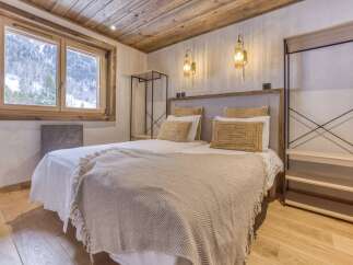 This cozy bedroom features a rustic wooden ceiling and flooring, creating a warm and inviting atmosphere.
