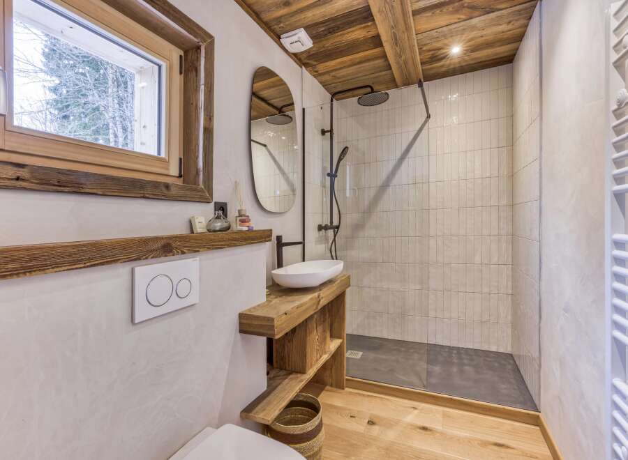 This stunning bathroom features a rustic design with wooden accents and a modern touch.