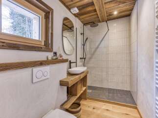 This stunning bathroom features a rustic design with wooden accents and a modern touch.