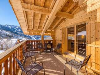 Enjoy breathtaking mountain views from this charming chalet balcony.