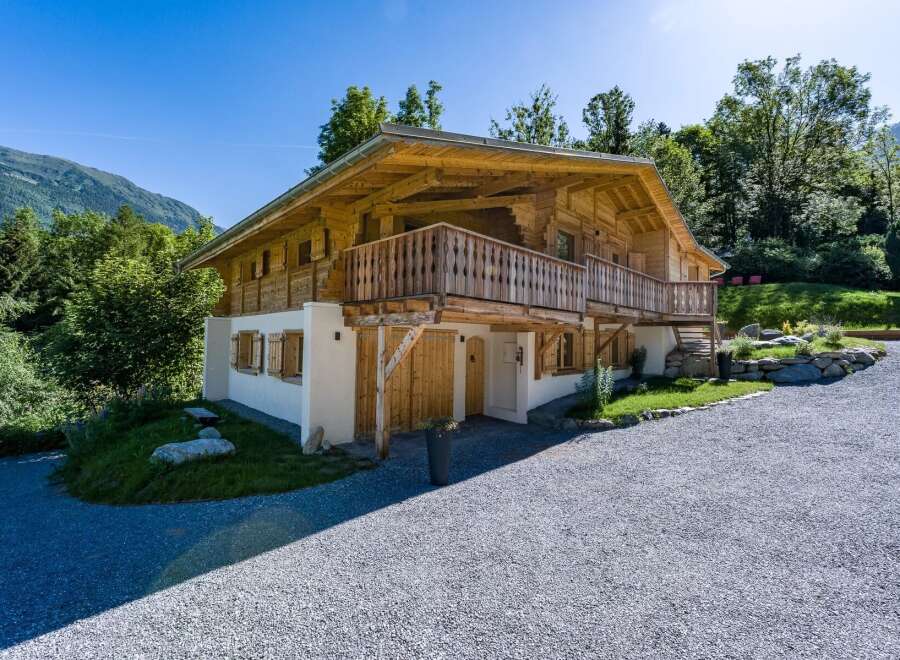 Experience alpine living in this stunning wooden chalet, nestled amidst lush greenery and majestic mountains.