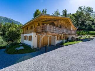 Experience alpine living in this stunning wooden chalet, nestled amidst lush greenery and majestic mountains.