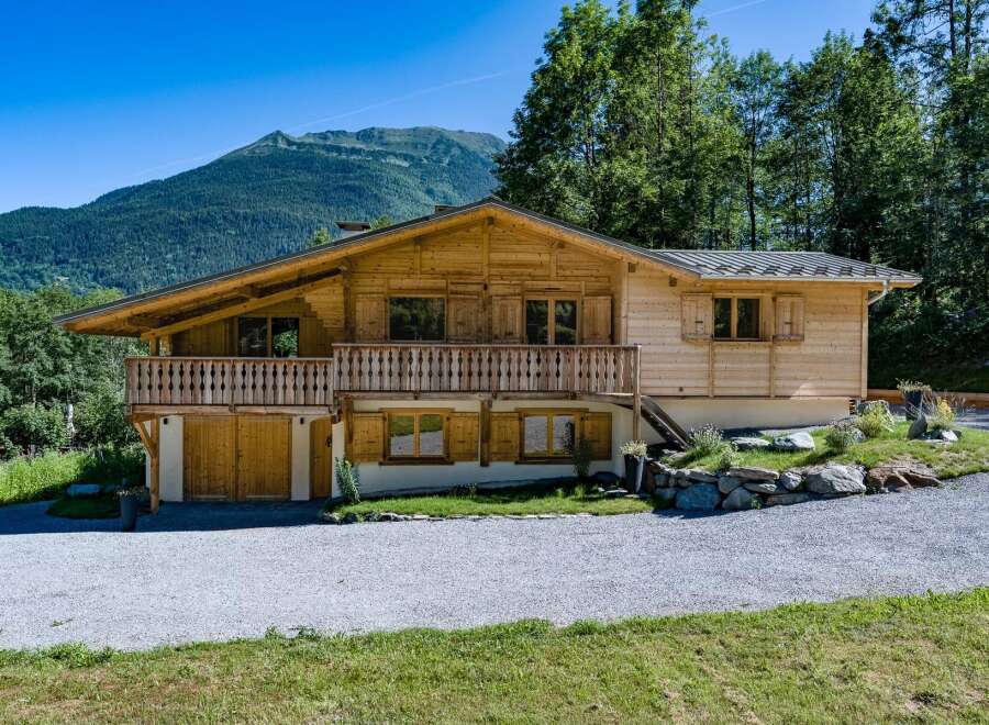 Experience alpine living in this charming wooden chalet, nestled against a backdrop of majestic mountains and lush greenery.