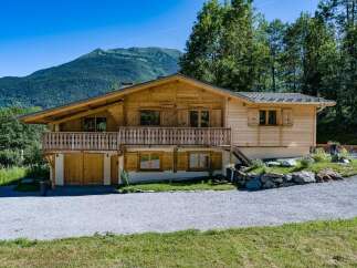 Experience alpine living in this charming wooden chalet, nestled against a backdrop of majestic mountains and lush greenery.