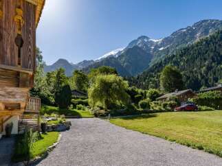 Experience the charm of alpine living in this picturesque property nestled against a backdrop of majestic snow-capped mountains.