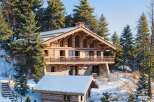 Nestled amidst a snowy landscape, this stunning wooden chalet offers a luxurious retreat.