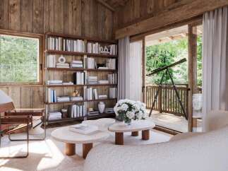 Step into a serene retreat with this stunning property, featuring a cozy interior with wooden walls and a large bookshelf.