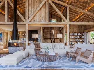 Experience rustic luxury in this stunning property, featuring exposed wooden beams and a cozy fireplace.