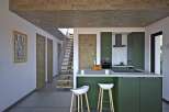 This modern kitchen boasts a sleek design with a green island and white countertops, perfect for culinary enthusiasts.