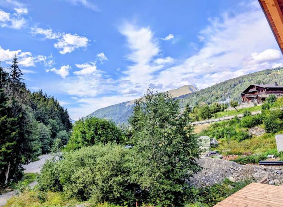 Experience breathtaking mountain views from this stunning property, nestled amidst lush greenery and towering trees.