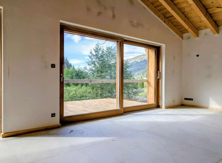 Experience breathtaking mountain views from this stunning property, featuring expansive sliding glass doors that open onto a private wooden deck.