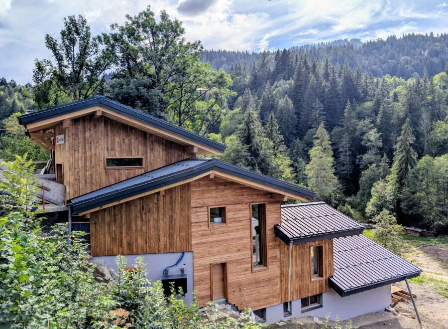 Discover this stunning modern chalet nestled amidst a lush, mountainous landscape.