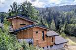 Discover this stunning modern chalet nestled amidst a lush, mountainous landscape.