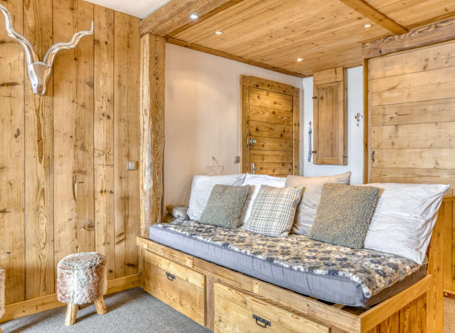 Discover the charm of this cozy retreat, featuring exquisite wooden paneling and a comfortable daybed.