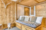 Discover the charm of this cozy retreat, featuring exquisite wooden paneling and a comfortable daybed.