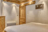 This charming bedroom features a rustic wooden door and ceiling beams, creating a warm and inviting atmosphere.