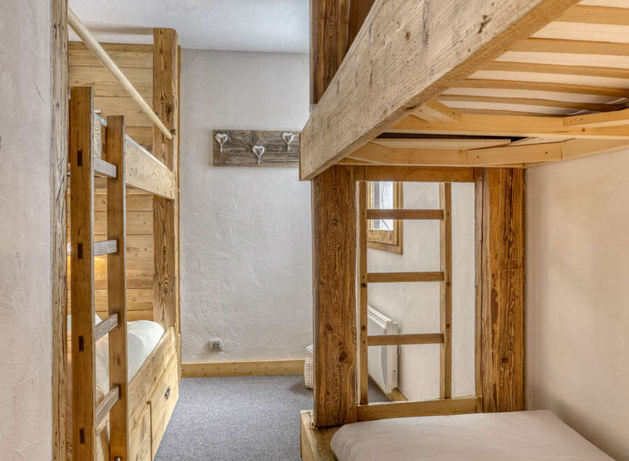This cozy bedroom features custom-built wooden bunk beds, perfect for a family or group of friends.
