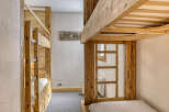 This cozy bedroom features custom-built wooden bunk beds, perfect for a family or group of friends.