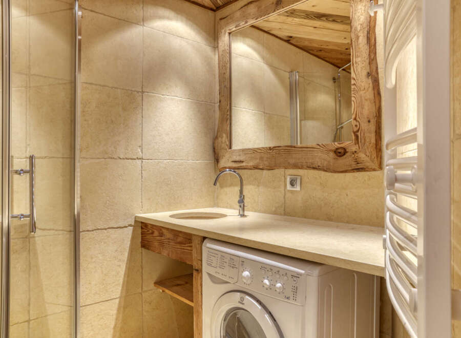 This rustic bathroom features a unique wooden-framed mirror and a stylish sink area.