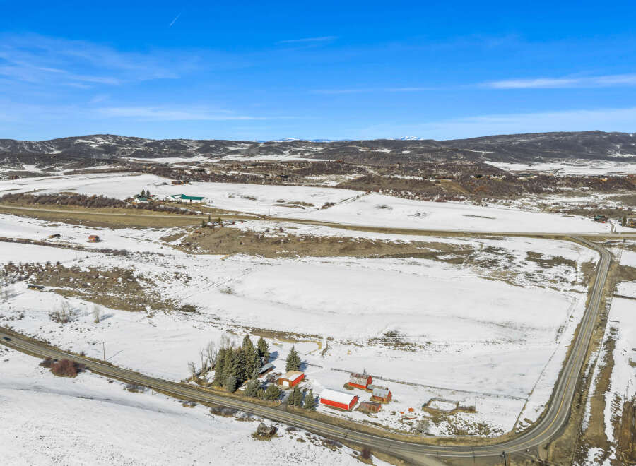 Discover a picturesque rural property nestled in a serene winter landscape.