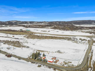 Discover a picturesque rural property nestled in a serene winter landscape.