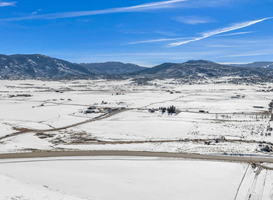 This stunning property offers breathtaking views of snow-covered fields and majestic mountains.
