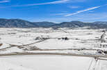 This stunning property offers breathtaking views of snow-covered fields and majestic mountains.