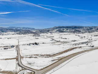 This stunning aerial view showcases a picturesque winter landscape, perfect for those seeking a serene retreat.