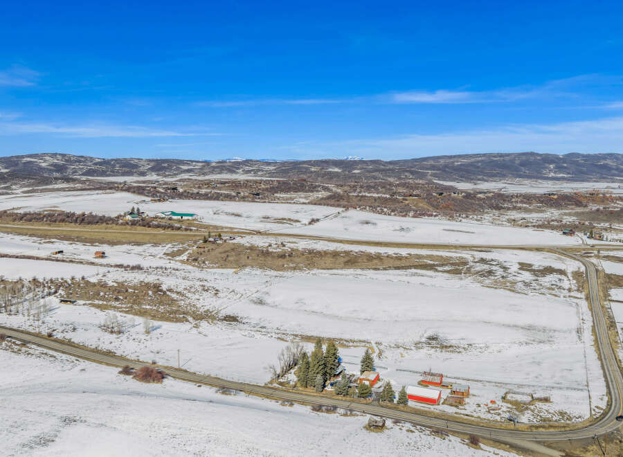 This stunning property offers a picturesque landscape with snow-covered fields and rolling hills.