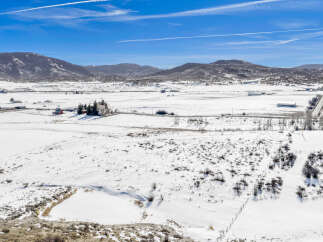 This stunning property offers a serene winter landscape, perfect for those seeking tranquility.