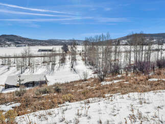 This stunning property offers a serene escape with breathtaking views of snow-covered landscapes and rolling hills.