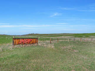 Discover this unique property featuring a rustic wooden sign with bold red lettering that reads 'JASPIP'.