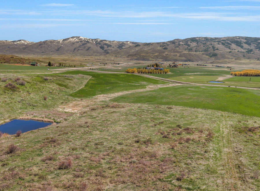 Discover this expansive rural property, featuring rolling green pastures and a serene pond, perfect for livestock or recreational use.