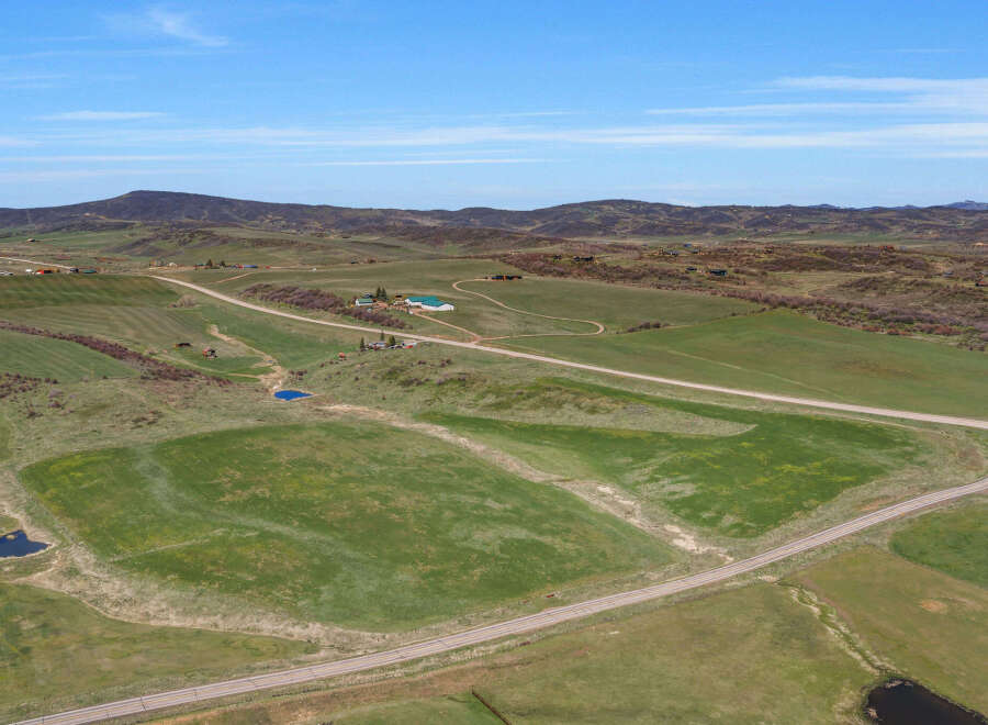 Discover this expansive rural property offering a serene landscape with rolling green hills and picturesque ponds.
