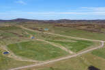 Discover this expansive rural property offering a serene landscape with rolling green hills and picturesque ponds.