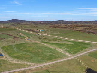 Discover this expansive rural property offering a serene landscape with rolling green hills and picturesque ponds.