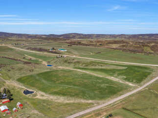 Discover this expansive rural property featuring rolling green hills, picturesque ponds, and a charming farmstead.