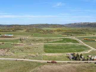 Discover this expansive rural property offering breathtaking panoramic views of rolling hills and distant snow-capped mountains.