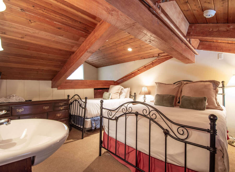 This charming bedroom features a unique, rustic design with exposed wooden beams and a cozy atmosphere.