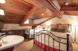 This charming bedroom features a unique, rustic design with exposed wooden beams and a cozy atmosphere.