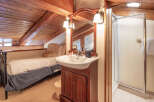 Discover the charm of this cozy bathroom, featuring a rustic wooden ceiling and a stylish vanity.