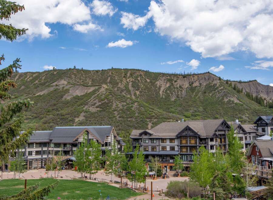 Discover this stunning mountain resort property, featuring a charming village atmosphere with modern architecture nestled against a dramatic natural landscape.