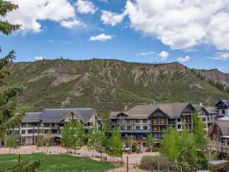 Discover this stunning mountain resort property, featuring a charming village atmosphere with modern architecture nestled against a dramatic natural landscape.