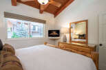 Experience rustic charm in this cozy bedroom featuring a comfortable bed with log accents and decorative pillows.