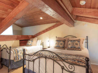 Discover this charming attic bedroom featuring two comfortable beds, perfect for accommodating guests.