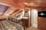 This charming attic bedroom features two cozy beds with rustic patterned blankets, perfect for a relaxing getaway.